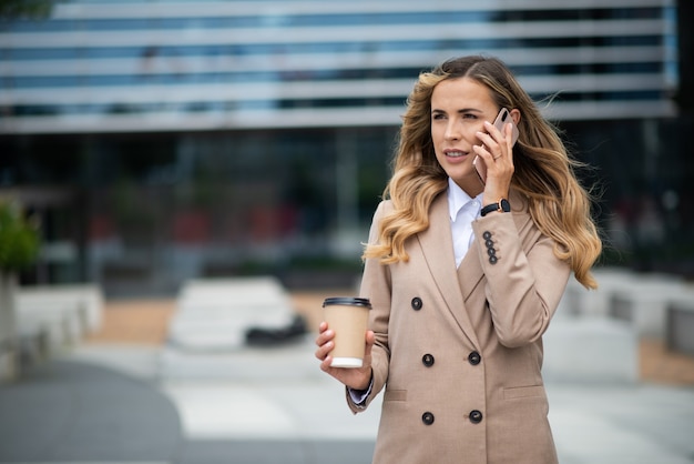 Young businesswoman talking on the phone in a city street