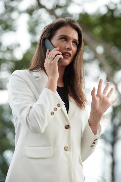 Giovane imprenditrice parlando al telefono