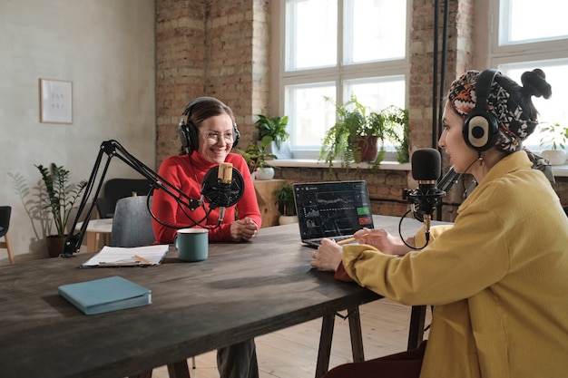 Young businesswoman talking to radio host during interview in radio studio