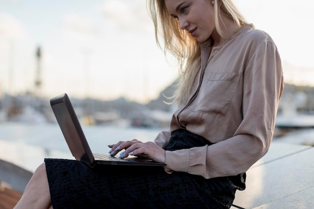 Молодая деловая женщина с ноутбуком на набережной