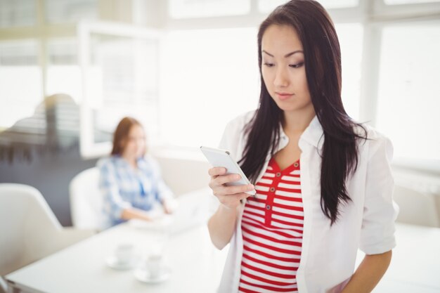 Young businesswoman using mobile phone at creative office