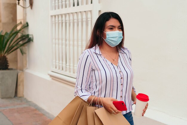 Young businesswoman wearing chewing gum and using a smartphone while walking around the city