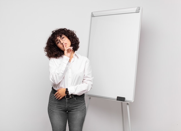 young businesswoman with curly hair and a white board