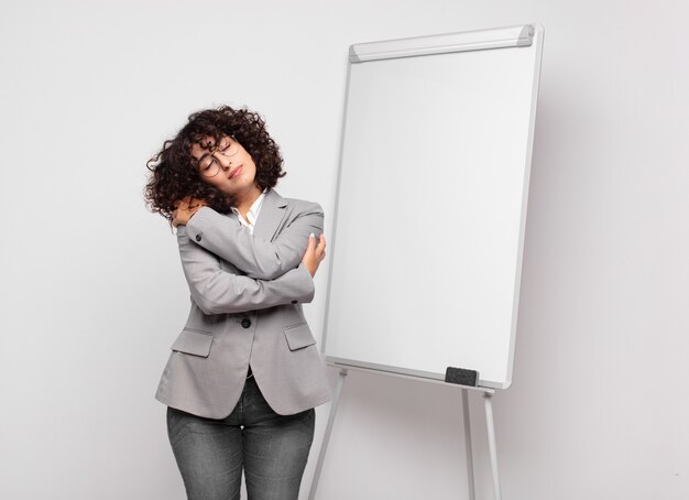 Young businesswoman with curly hair and a white board