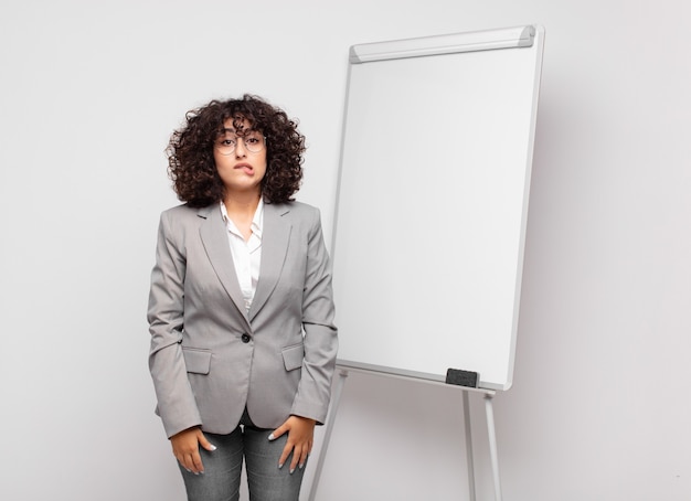 young businesswoman with curly hair and a white board