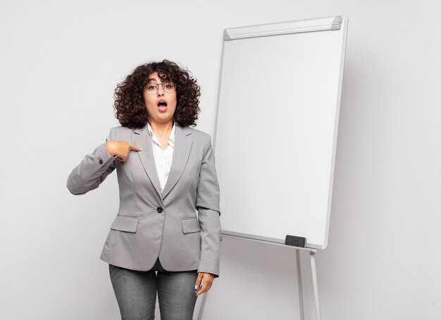 Photo young businesswoman with curly hair and a white board