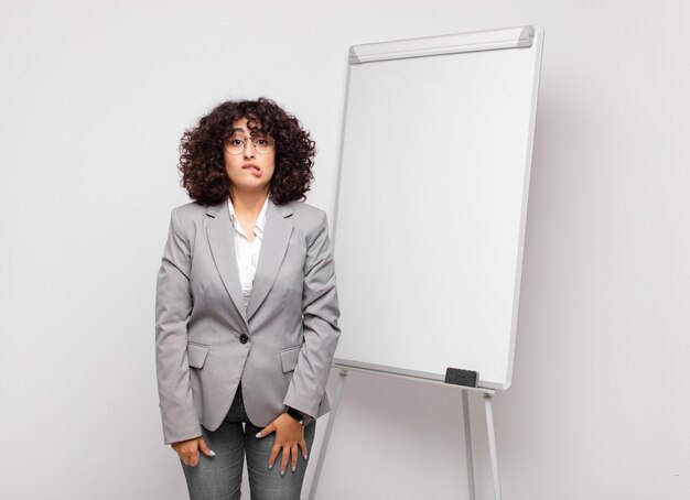 young businesswoman with curly hair and a white board