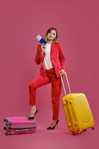 Young businesswoman with suitcases, holding passport and ticket. Business travel concept