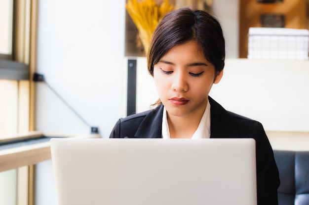 Photo young businesswoman working on laptop in office