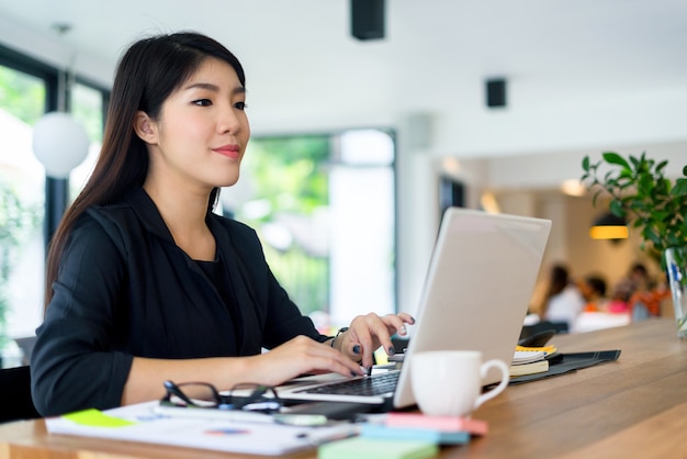 young businesswoman working with mobile laptop and documentsin office