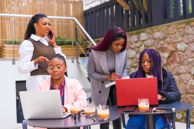 Young businesswomen of black ethnicity. At a business meeting in a cafeteria with computers and coffee on the table