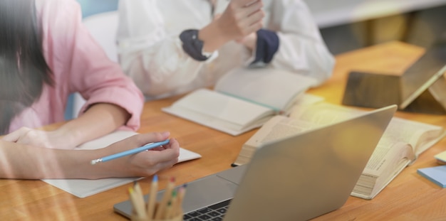 Young campus students studying together in library  