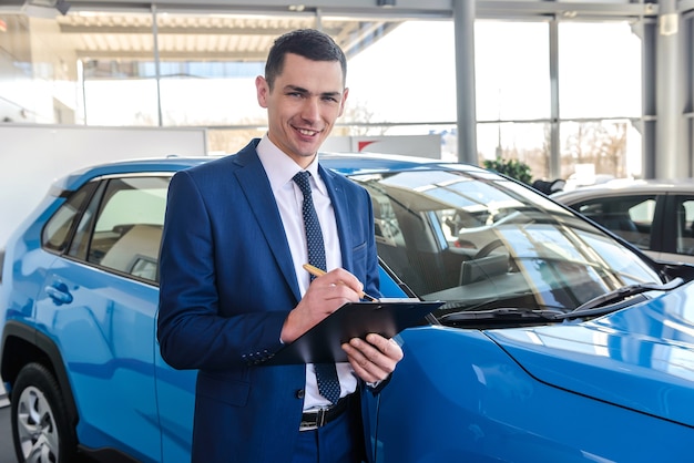 young car dealer holding clipboard in salon