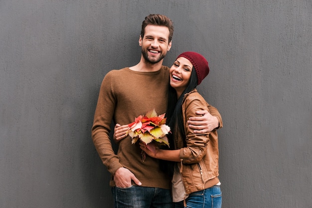 Young and carefree. Beautiful young couple bonding to each other and smiling 