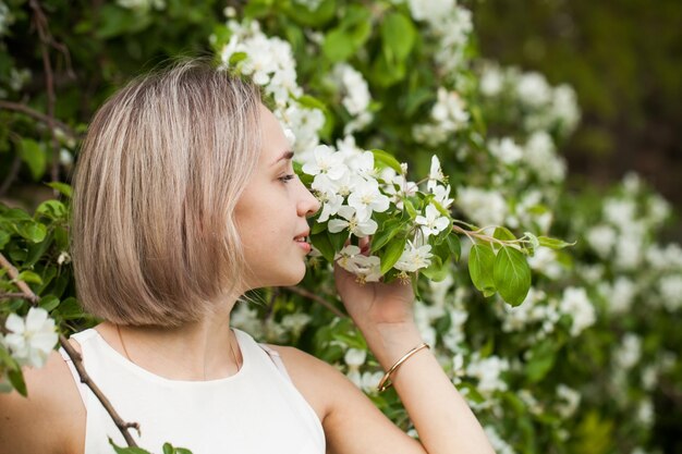 Photo young carefree woman smelling the flowers in spring park