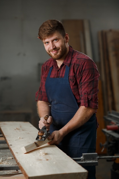 Young carpenter with an apron in his workshop