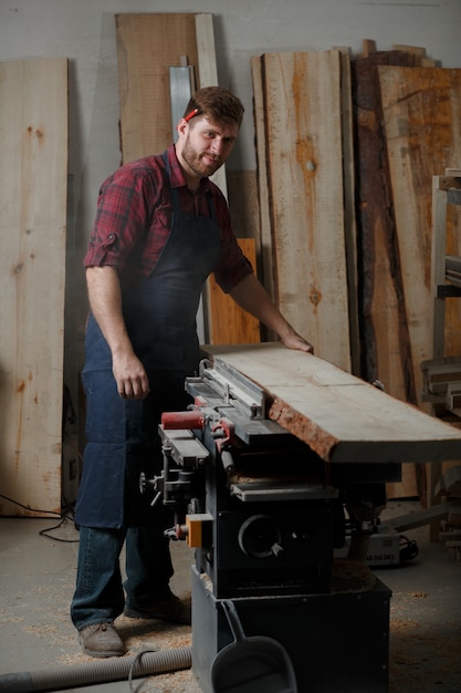 Young carpenter with an apron in his workshop