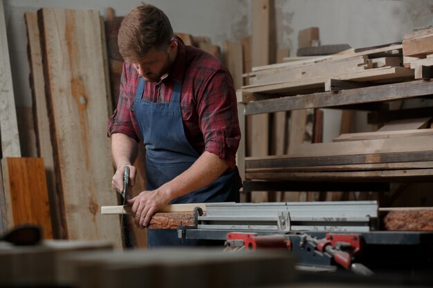 Young carpenter with an apron in his workshop