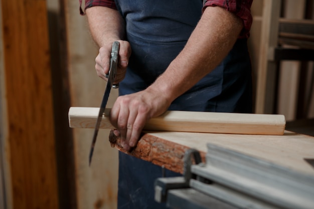 Young carpenter with an apron in his workshop