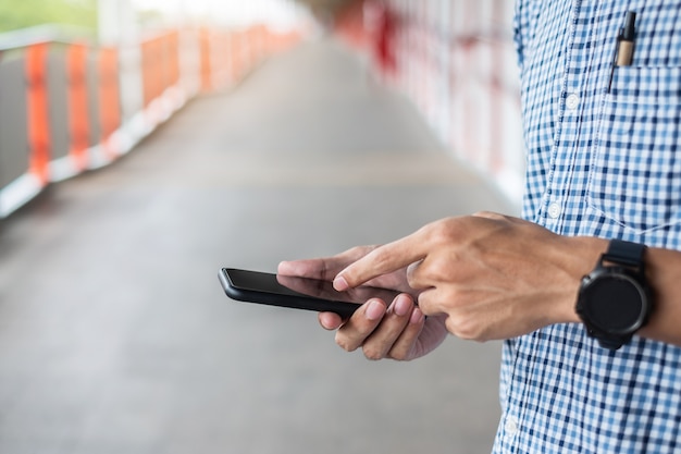 Young casual Businessman holding and using smartphone 