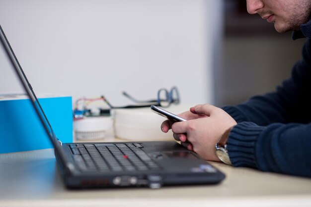 Young casual businessman using smartphone in the startup office