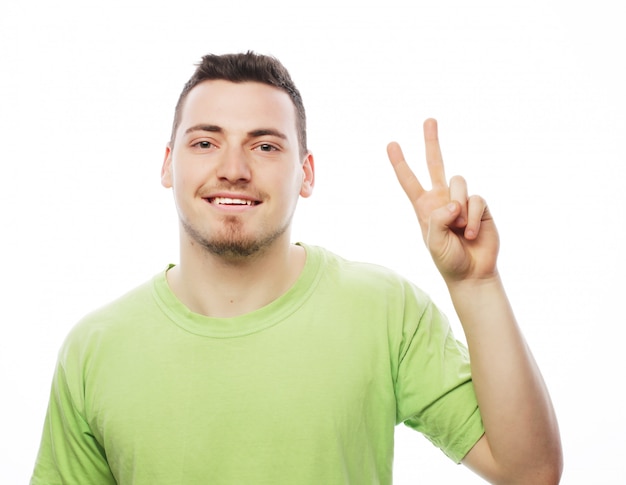 Young casual man showing the victory gesture