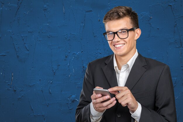 Young casual man texting onhis smartphone