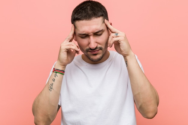 Young casual man touching temples and having headache.