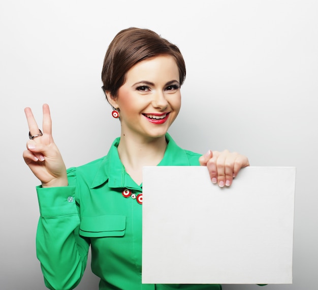 Young casual woman happy holding blank sign 