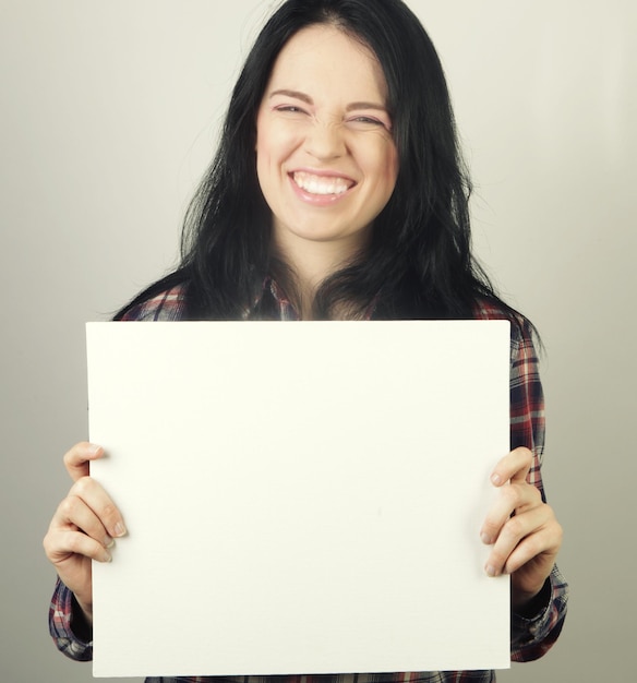 Young casual woman happy holding blank sign