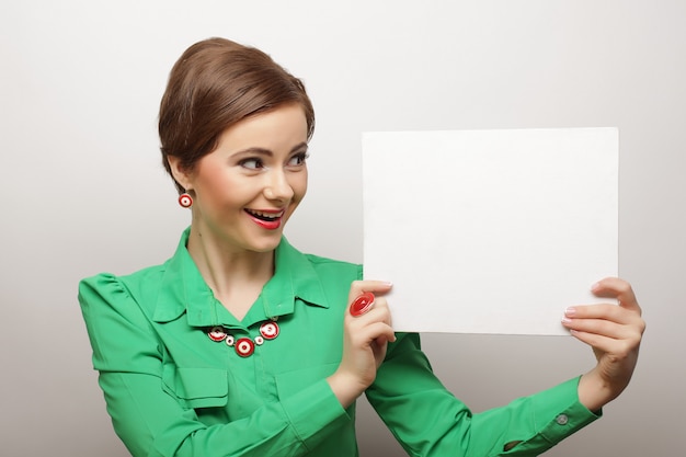 Young casual woman happy holding blank sign 