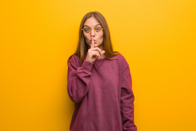 Young casual woman keeping a secret or asking for silence