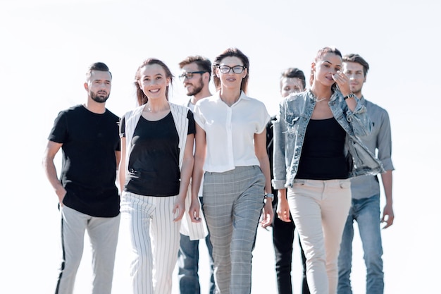 Young casual woman leader walking forward in front of her group