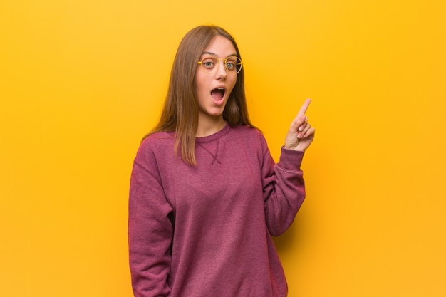 Young casual woman pointing to the side