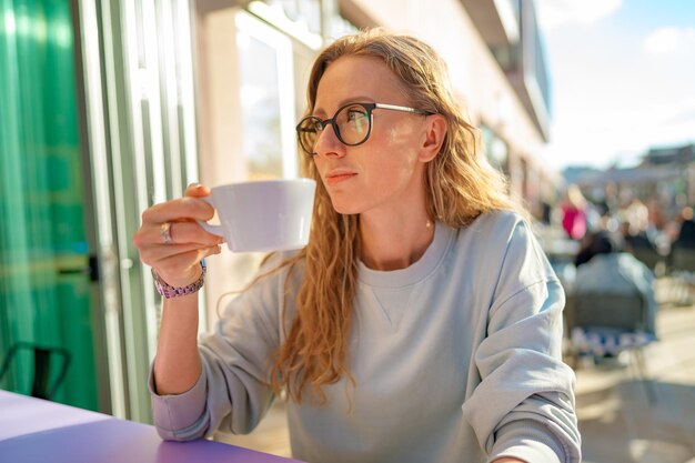 Young casual woman sitting at the table in coffeeshop