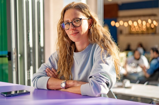 Young casual woman sitting at the table in coffeeshop