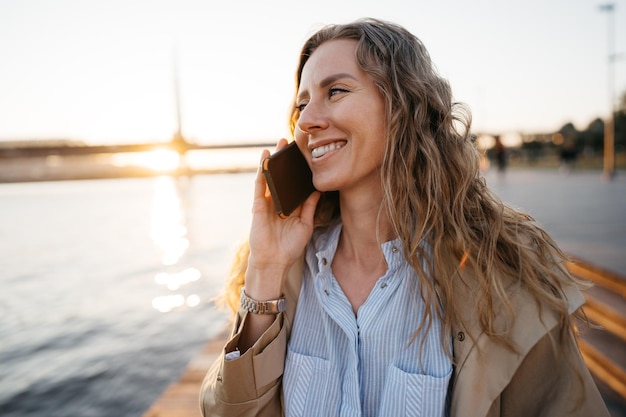 Giovane donna casual che parla sullo smartphone in città