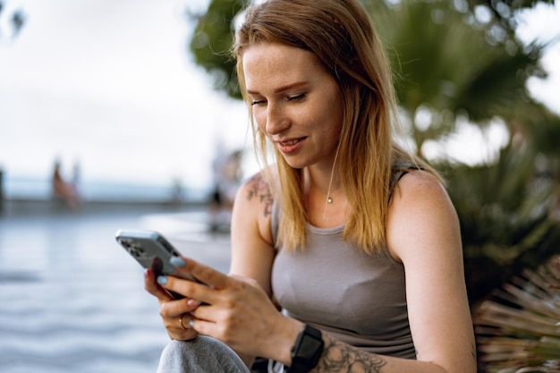 街でスマートフォンを使っている若いカジュアルな女性