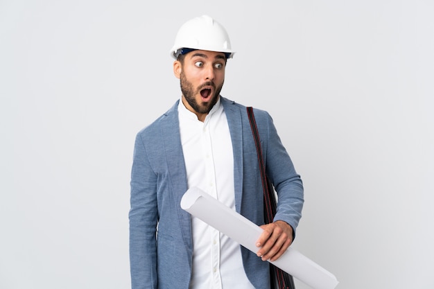 Young caucasian architect man over isolated white wall