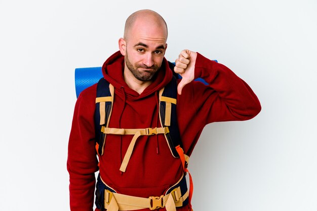 Young caucasian backpacker bald man isolated on white wall showing a dislike gesture, thumbs down