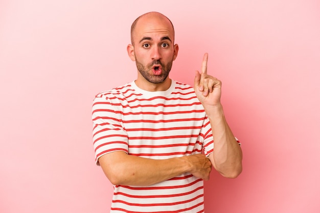 Photo young caucasian bald man isolated on pink background  having some great idea, concept of creativity.