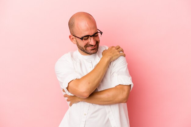 Young caucasian bald man isolated on pink background  laughing and having fun.