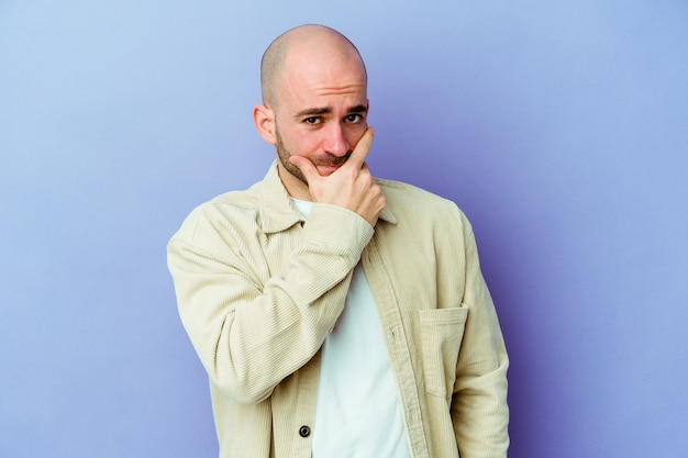 Young caucasian bald man on purple contemplating, planning a strategy, thinking about the way of a business.