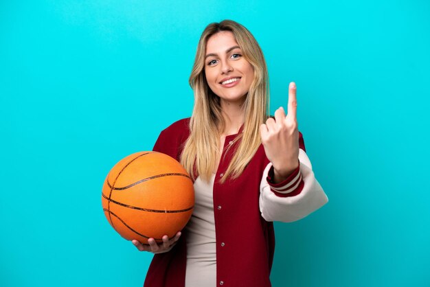 Young caucasian basketball player woman isolated on blue background doing coming gesture