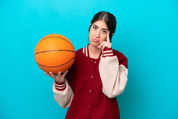 Young caucasian basketball player woman isolated on blue background thinking an idea