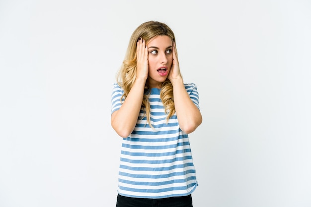 Young caucasian blonde woman covering ears with hands trying not to hear too loud sound.