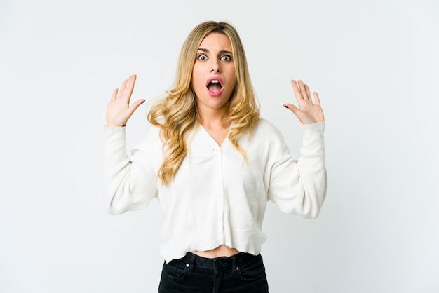 Young caucasian blonde woman screaming to the sky, looking up, frustrated.