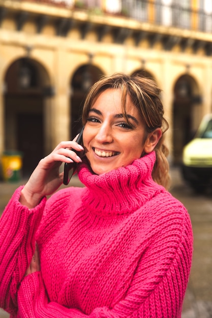 Young caucasian blonde woman talking by phone at the street