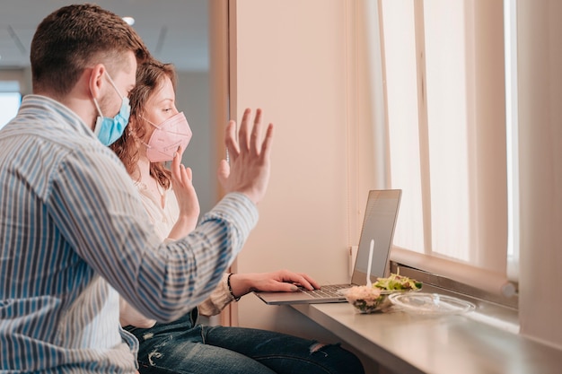 Young Caucasian boy and woman working with face masks teleworking