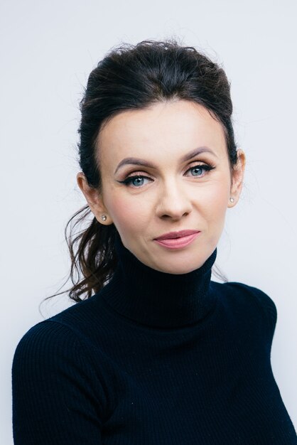 Young caucasian brunette woman in black top with blue eyes, fresh skin, nude make-up